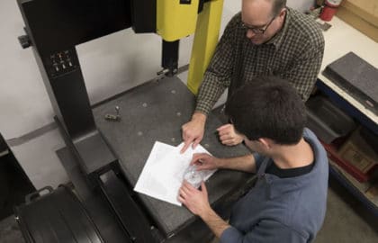 complex tight tolerance injection molding engineers inspecting part feature